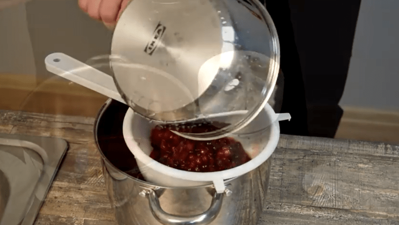 Фильтрация клюквы через сито